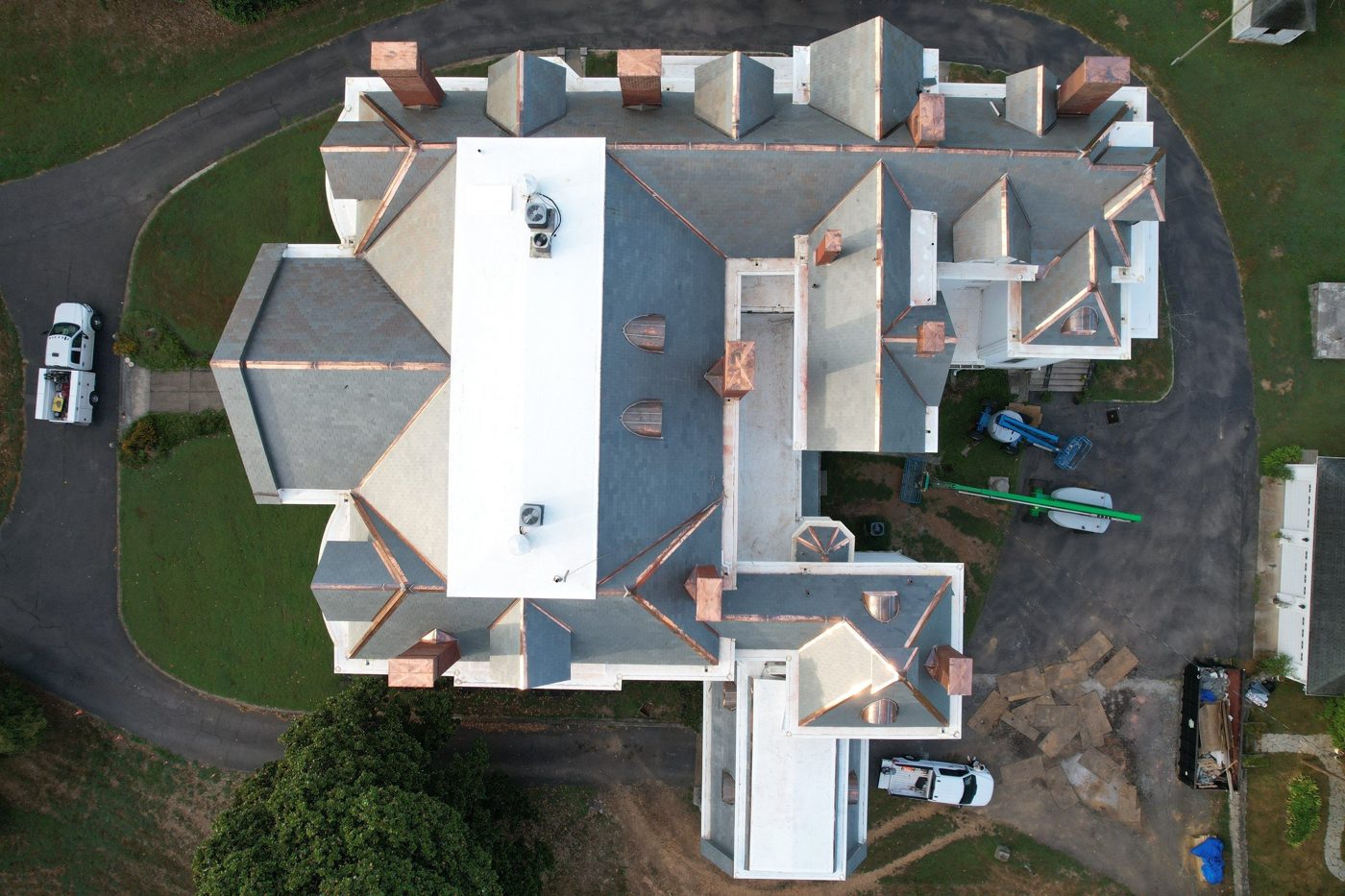 Aerial view of a slate roof estate with custom copper chimney caps